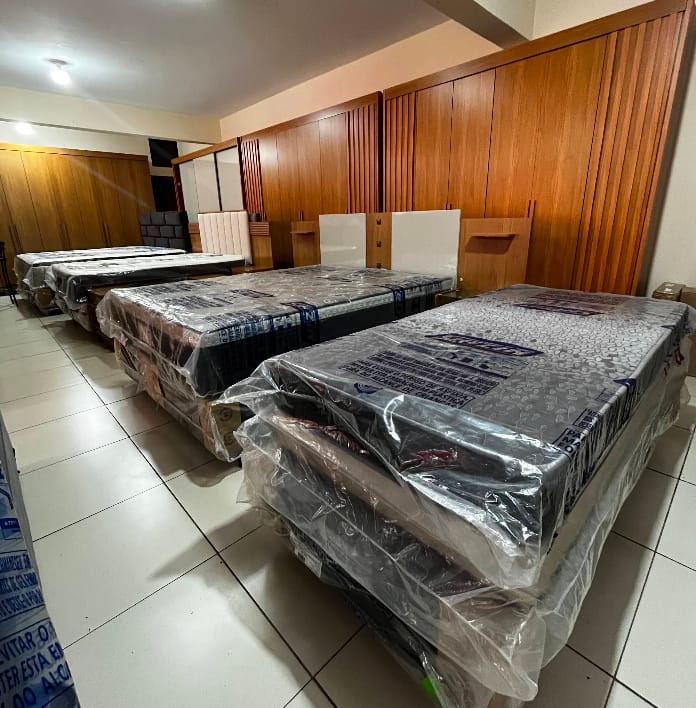 Guarda-roupas de madeira ao fundo e camas de solteiro